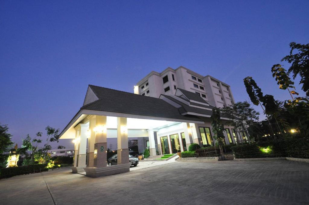 a large white building with lights in a parking lot at Pearl Resort & Hotel in Nonthaburi
