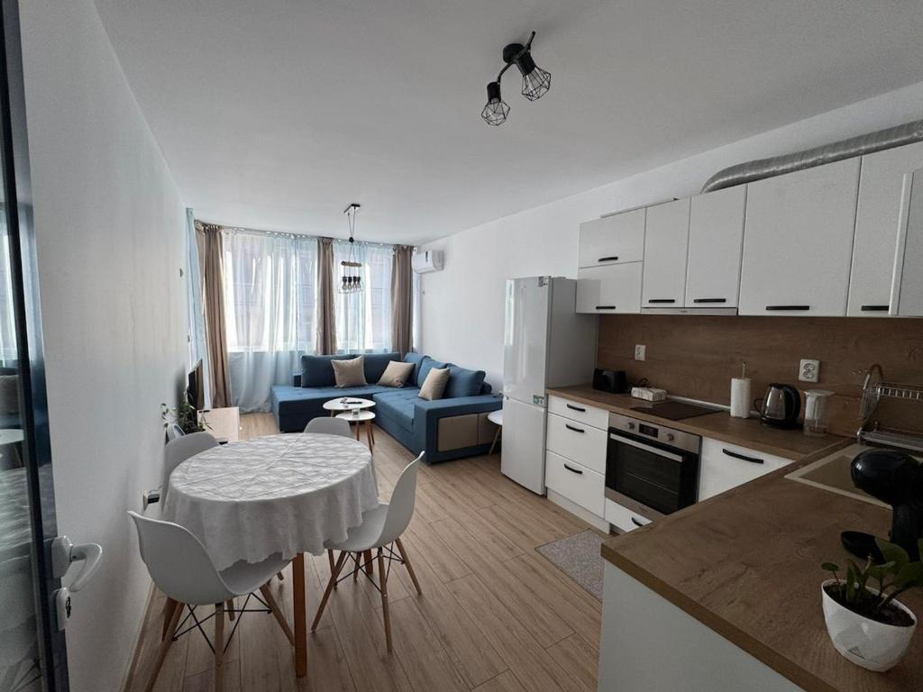 a kitchen and a living room with a table and chairs at Apartment Bela in Burgas City