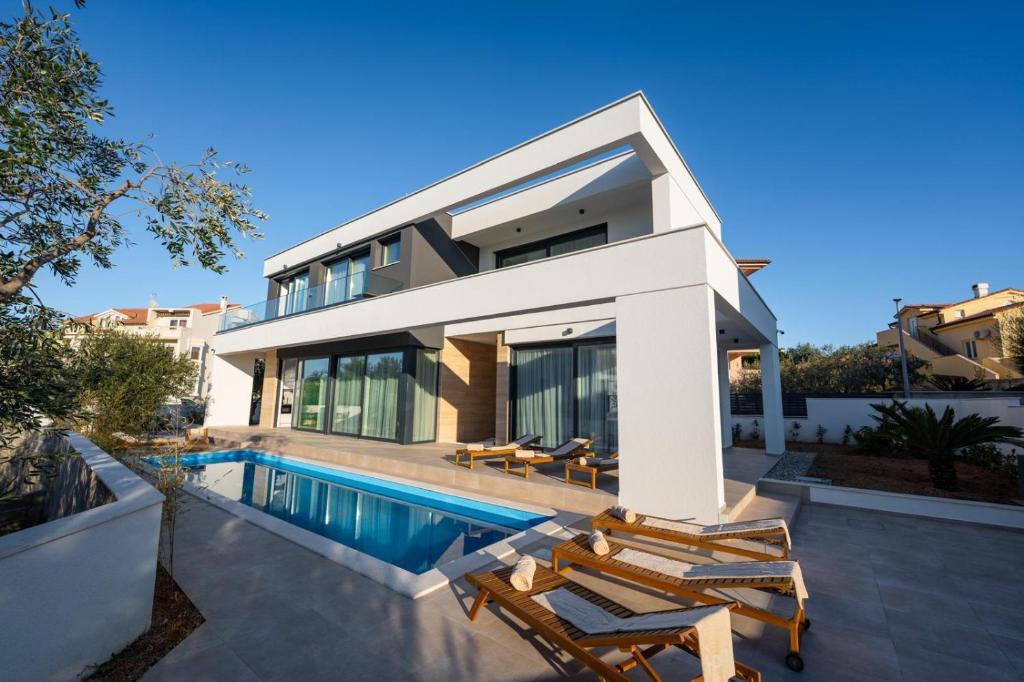 a villa with a swimming pool and a house at Elegant Villa Cataleya with private pool and sauna in Novalja