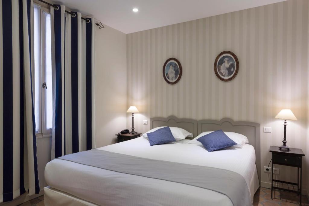 パリにあるホテル モガドールのベッドルーム(青い枕の大きな白いベッド付)