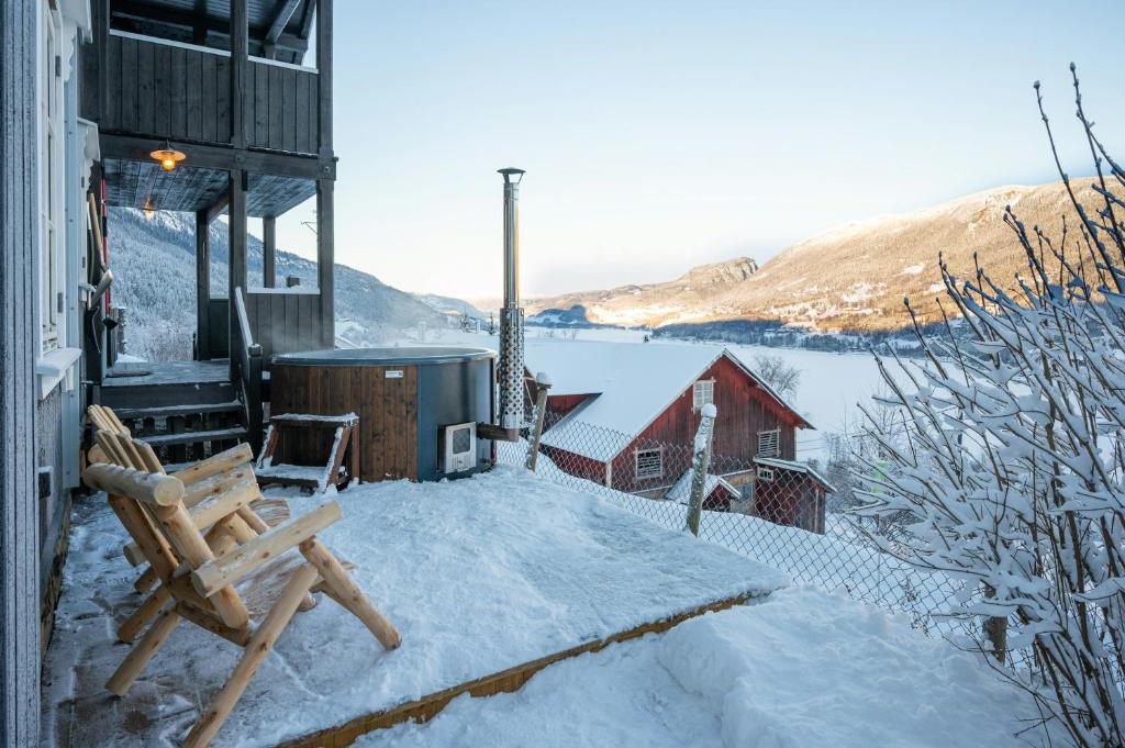 a snow covered patio with a bench and a building at Historic Farm With Panoramic Views In Gudbrandsdalen in Favang