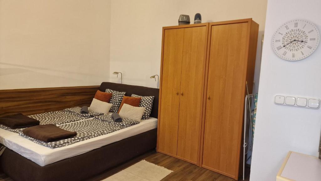 a bedroom with a bed and a wooden cabinet at Dombóvári way apartment in Budapest
