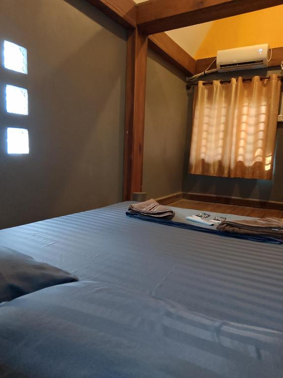 a bedroom with a blue bed with a window at Lazy Bones in Koh Rong Sanloem
