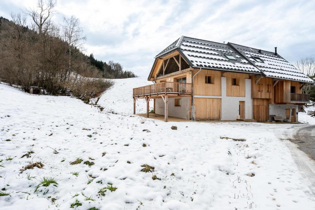 una casa nella neve con un cortile coperto di neve di La grange de Fernande - 8 personnes a Jarsy