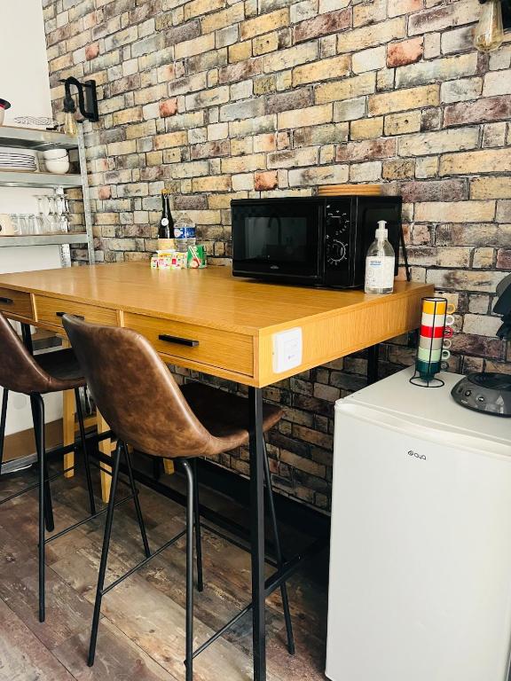 Un four micro-ondes est installé au-dessus d'une table en bois. dans l'établissement Comfy Loft - Dalby, à Nantes
