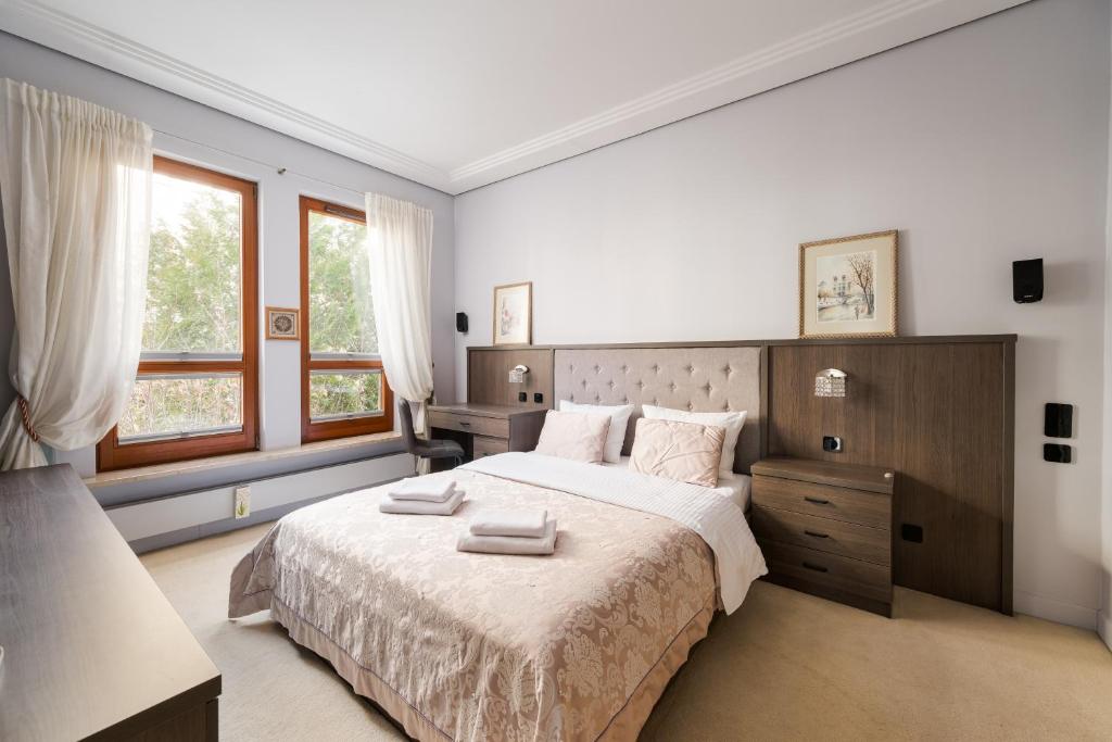 a bedroom with a large bed with two towels on it at Royal Wilanów Spacious Apartment by BookingHost in Warsaw
