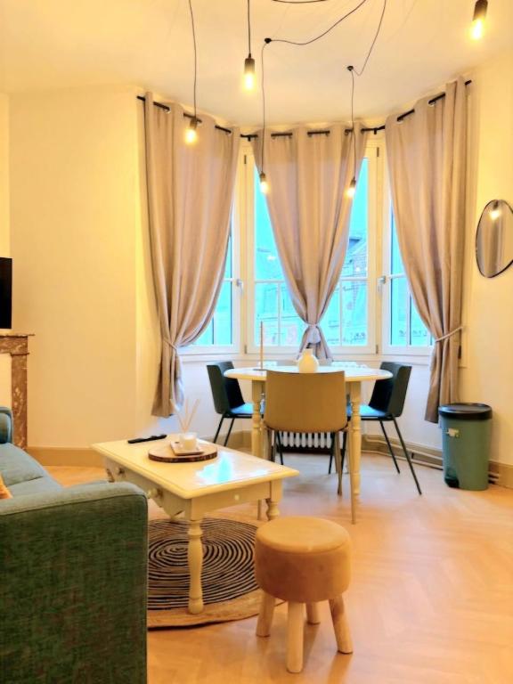 un salon avec une table et des chaises dans l'établissement Appartement cosy au cœur de Saint Quentin, à Saint-Quentin