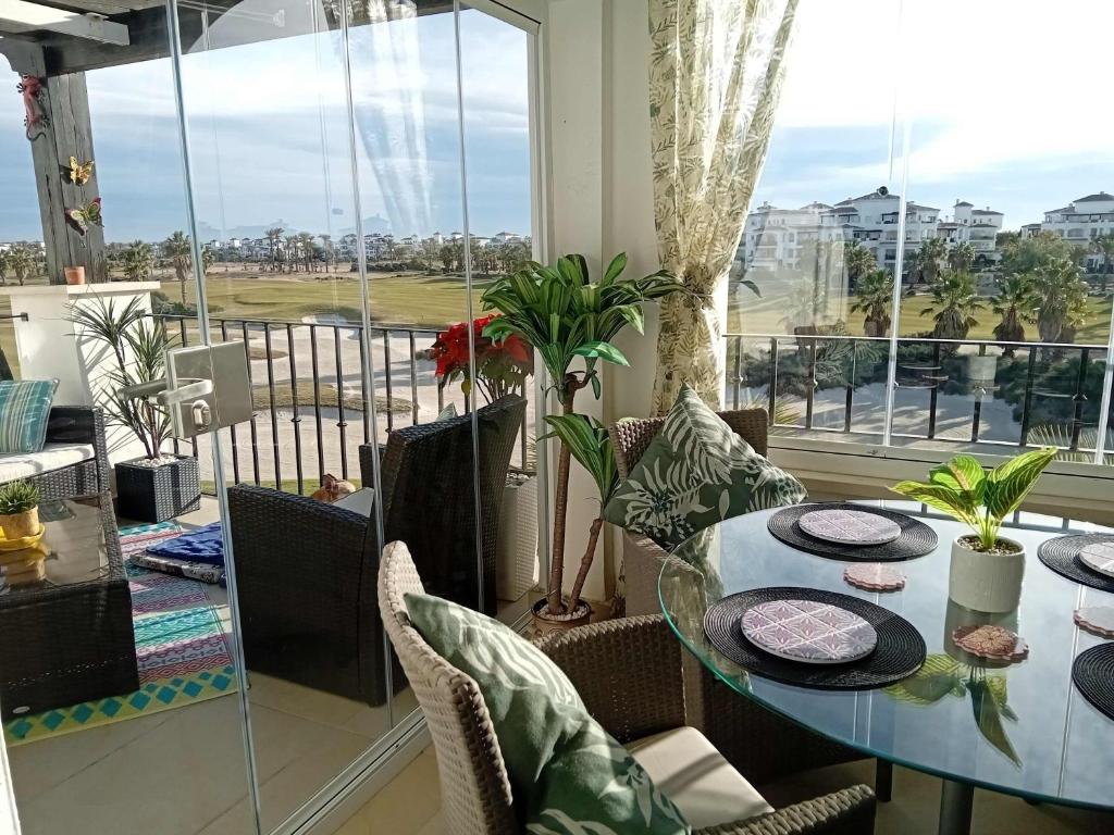 ein Esszimmer mit einem Tisch und einem großen Fenster in der Unterkunft A Lovely Two Bedroom Apartment at La Torre Golf Resort - PA721LT in Roldán