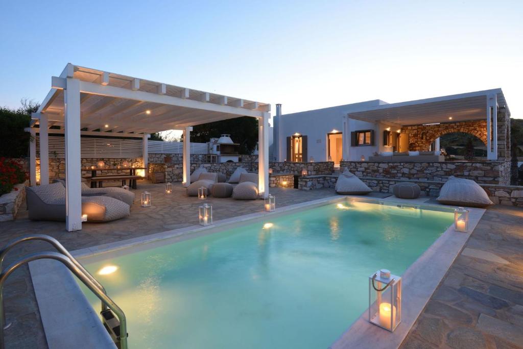 einen Pool mit Terrasse und ein Haus in der Unterkunft Executive Paros Villa 4 Bedrooms Villa Almyrikia Sunset Stunning Sea View in Kampos Paros