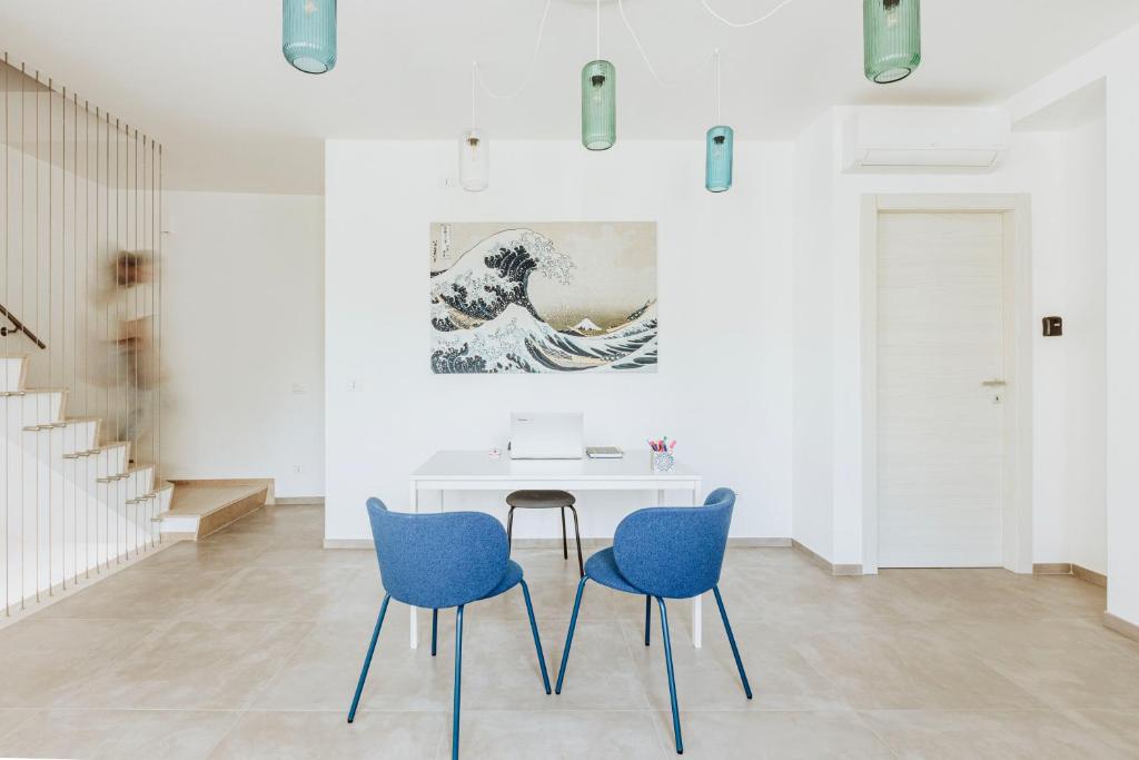 a white room with blue chairs and a table at Marechiaro Room in Vasto