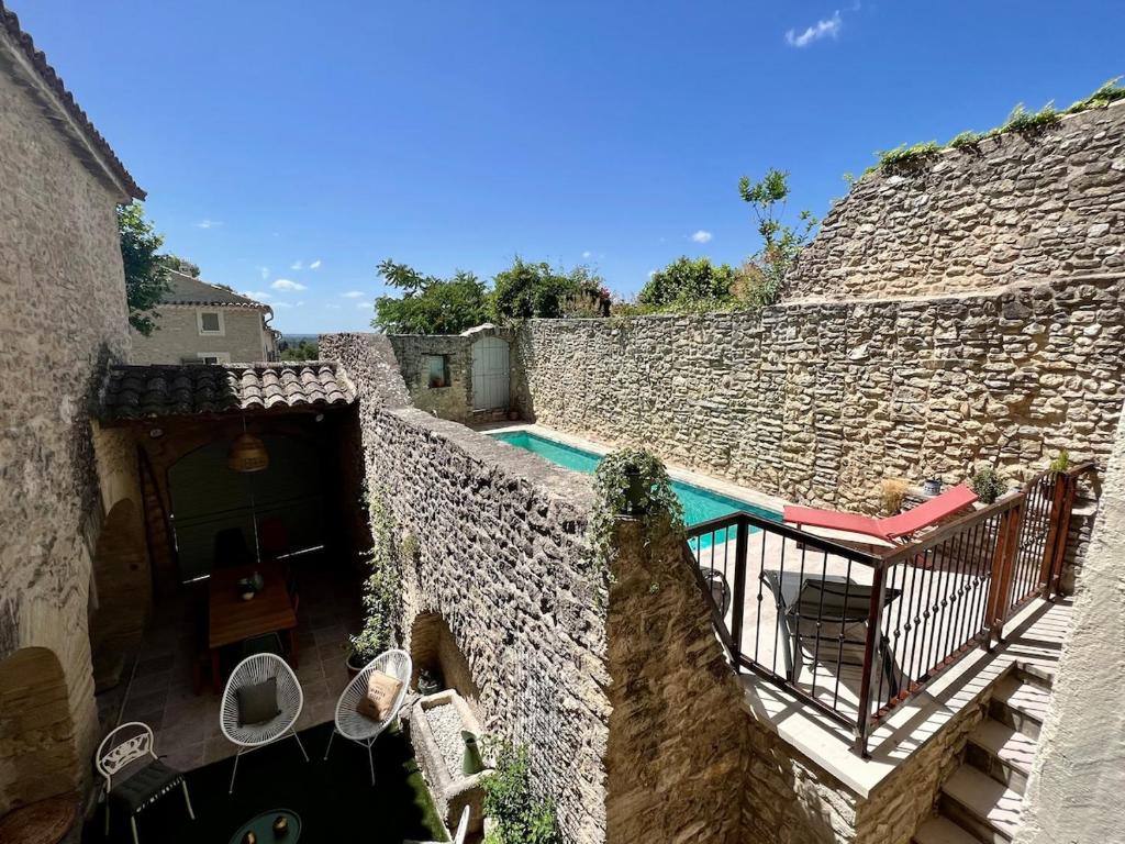 - une vue extérieure sur un bâtiment en pierre avec une piscine dans l'établissement La Villa 1777, à Lagnes