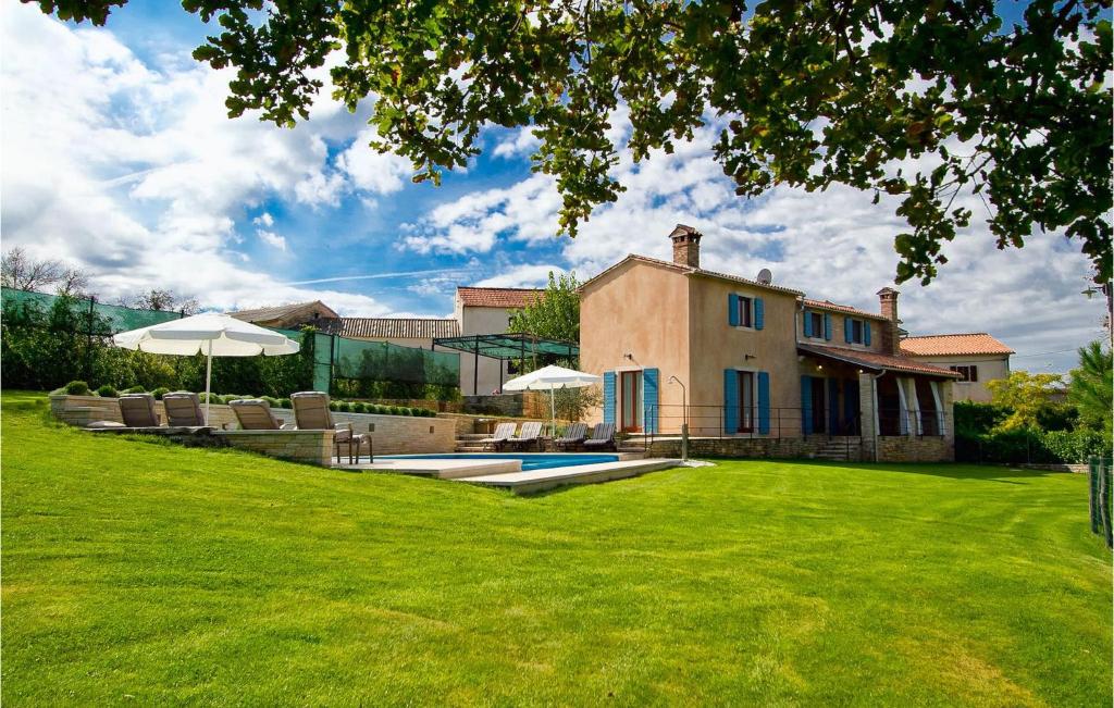 een huis met een tuin met een zwembad en parasol bij Villa Valica in Veli Ježenj