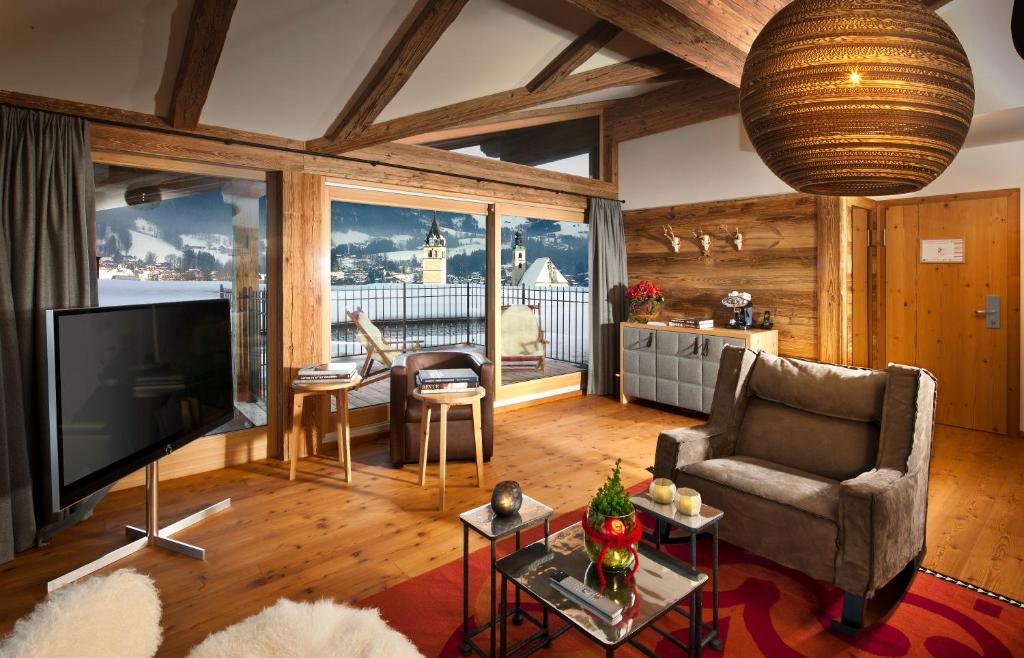 a living room with a flat screen tv and a couch at Kitzhof Mountain Design Resort in Kitzbühel