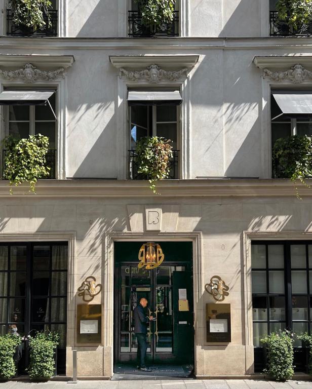 a man standing at the door of a building at Le Burgundy Paris in Paris