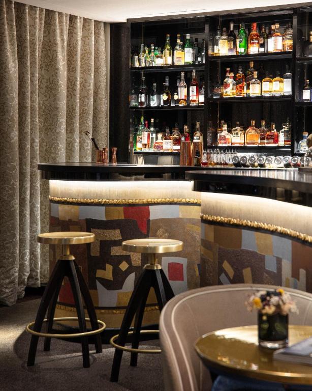 a bar in a restaurant with two tables and chairs at Le Burgundy Paris in Paris