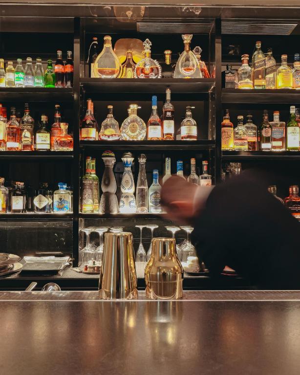 a bar with a person in front of a shelf of alcohol at Le Burgundy Paris in Paris
