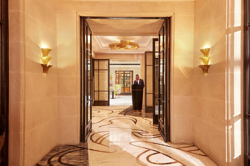 a man in a suit standing in a hallway at Le Burgundy Paris in Paris