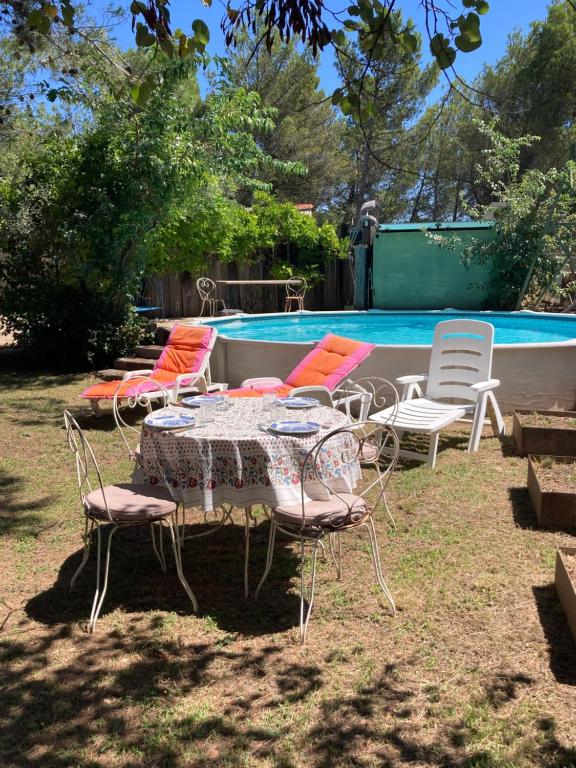 - un groupe de chaises et une table à côté de la piscine dans l'établissement Villa L Oasis avec piscine, aux Angles (Gard)