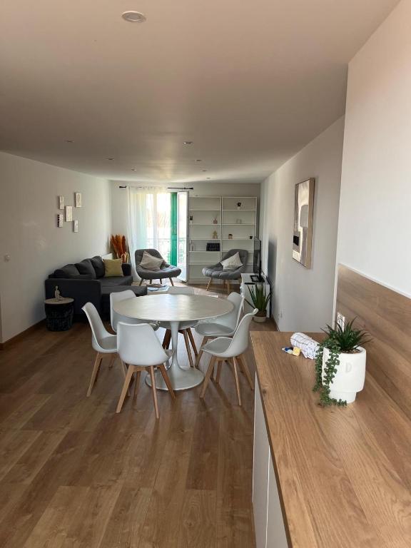 un salon avec une table, des chaises et un canapé dans l'établissement Charmant T3 centre ville proche gare Perpignan, à Perpignan