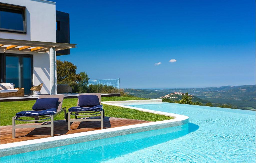 two chairs sitting on a deck next to a swimming pool at Villa Vista in Zamask