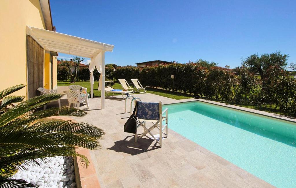 a swimming pool with two chairs and a table and avisor at Gorgeous Home In Capezzano Pianore in Capezzano Pianore,