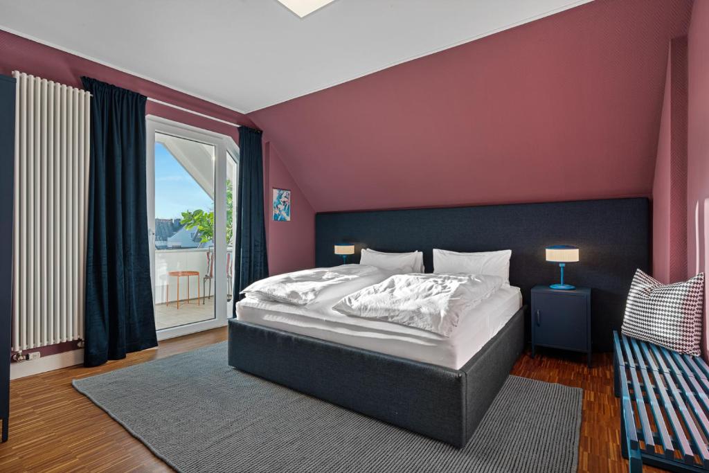 a bedroom with a large bed with a purple wall at CLS Moderne Villa Bad Schwartau mit Garten für bis zu 6 Personen, 2 E-Ladesäulen, 3 Parkplätze, Loggia, Big GREEN EGG, Massagesessel, großes Haus zwischen Lübeck und Ostsee, ideale A1 Anbindung nach Hamburg, Lübeck, Timmendorfer Strand in Bad Schwartau