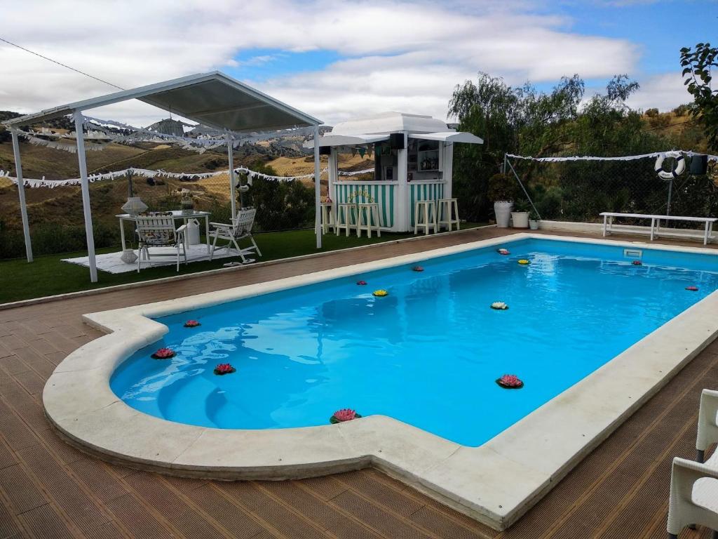 einen Pool mit blauem Wasser und einem Pavillon in der Unterkunft Casa Rural El Almendro in Olvera