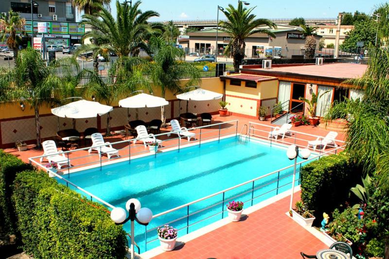 una vista aérea de una piscina con sillas y sombrillas en Hotel La Villa, en Misterbianco