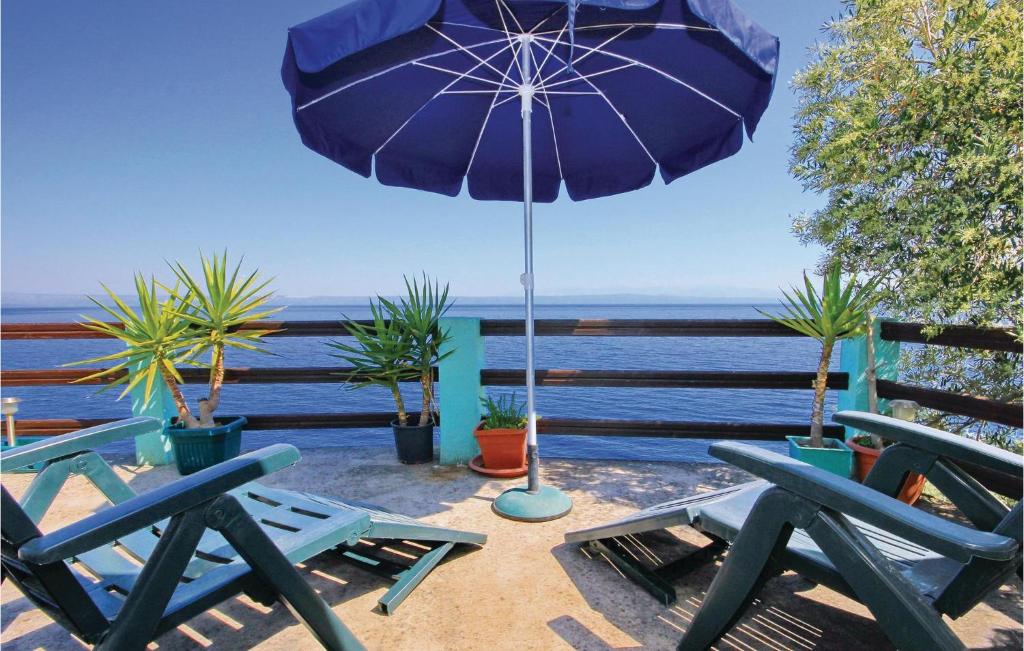 un patio con due sedie blu e un ombrellone di Holiday Home Blaca Bb Ii a Prigradica