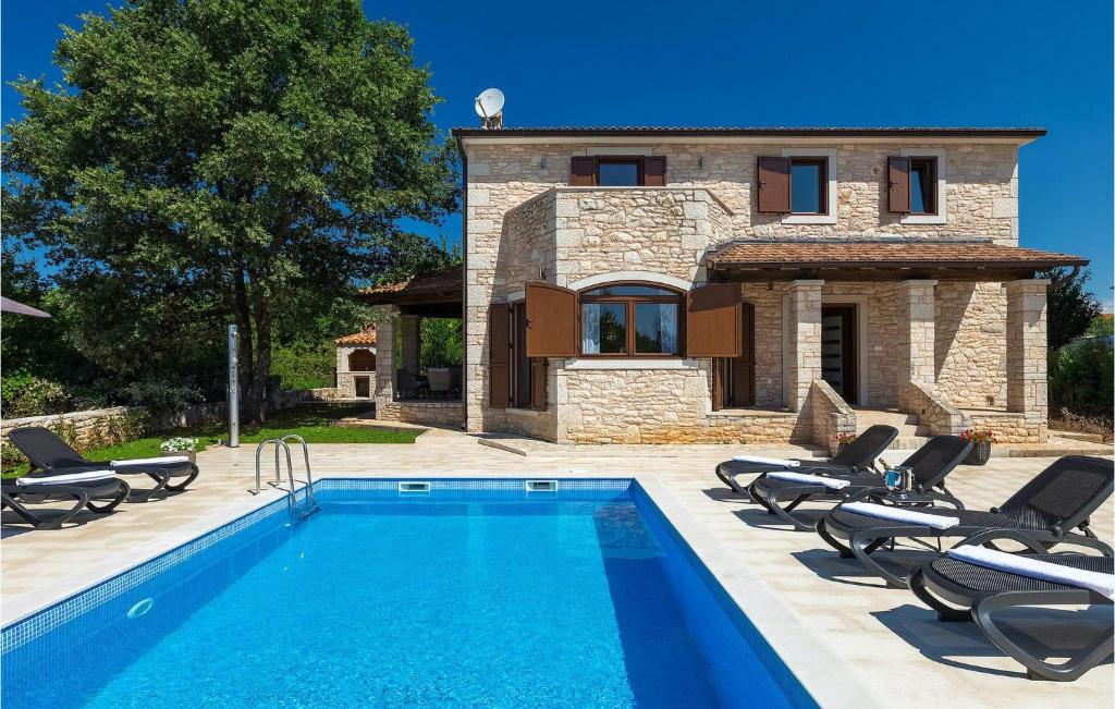 a villa with a swimming pool in front of a house at Villa Botanica Istria in Poreč