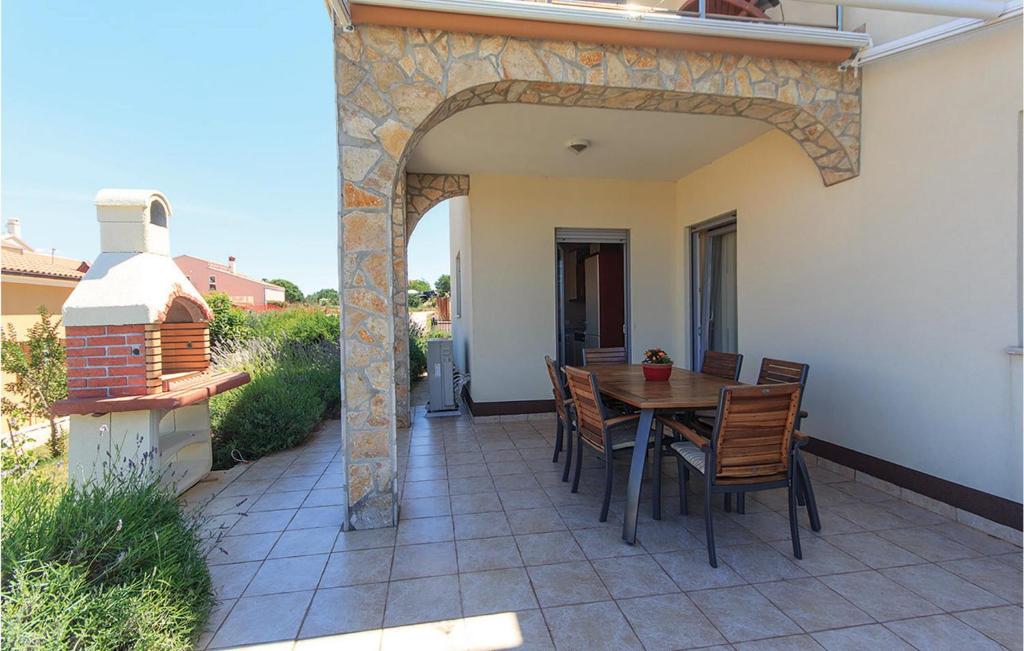 patio ze stołem i krzesłami na domu w obiekcie Holiday Home Volme w Puli