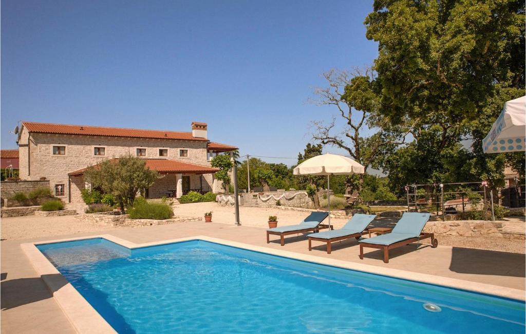 - une piscine avec 2 chaises longues et une maison dans l'établissement Villa Marija Korenici, à Rovinj