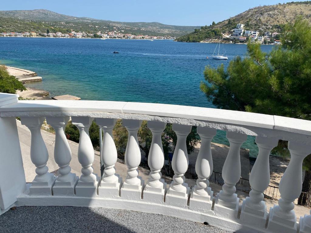 einen weißen Balkon mit Blick auf das Wasser in der Unterkunft Oktobus in Rogoznica