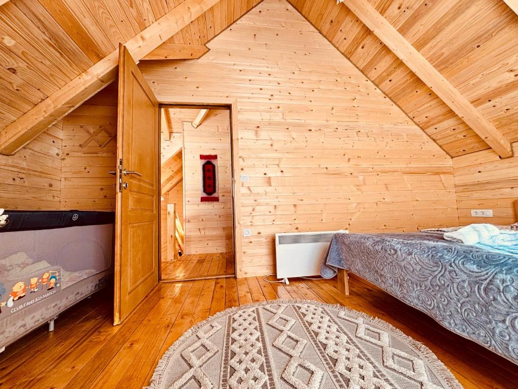 a bedroom with a bed in a wooden room at Alfa Omega Žabljak in Žabljak