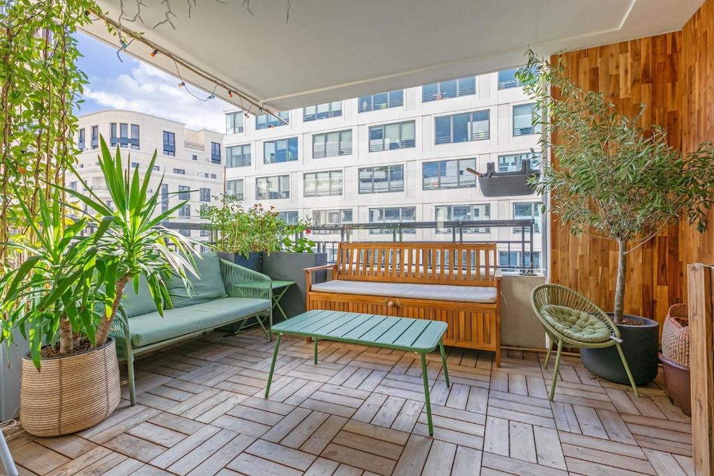 a balcony with a bench and a table and plants at La Casita Mexicana - Kids Friendly by So Homy- 3 Bed Room - 6 PAX in Saint-Ouen