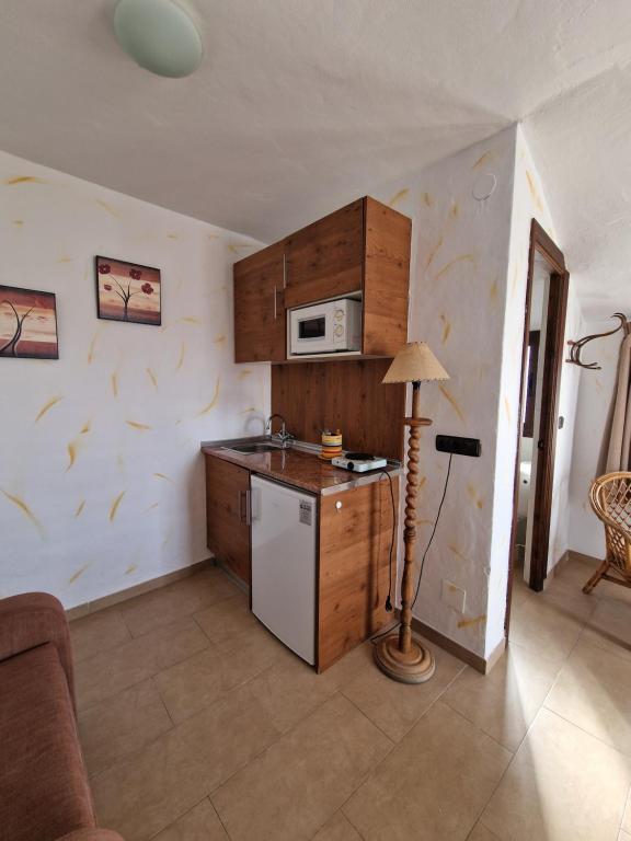 y cocina con nevera y microondas. en Hospedería El Caravansar, en Frigiliana