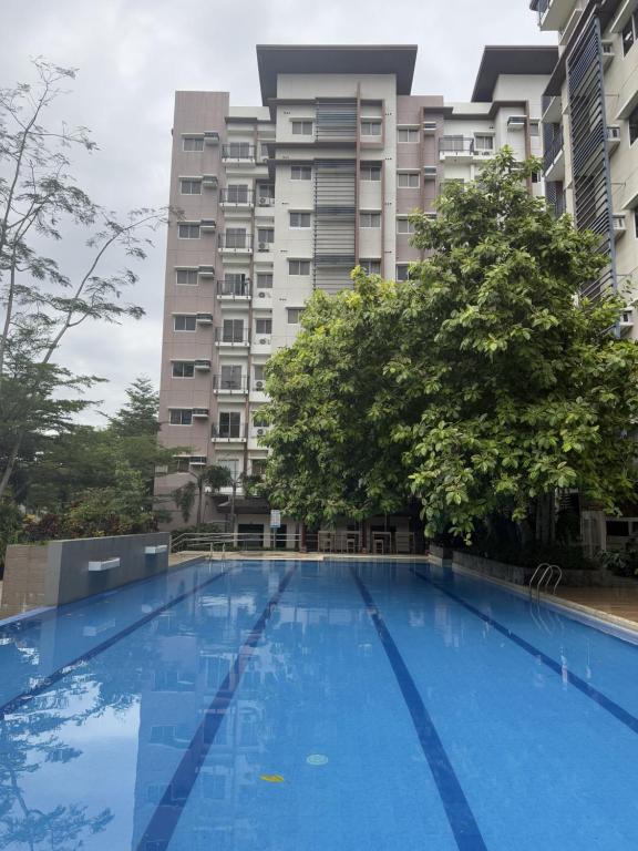 a large blue swimming pool in front of a building at Asters - Two Bedroom Condo Unit with Balcony in Davao City