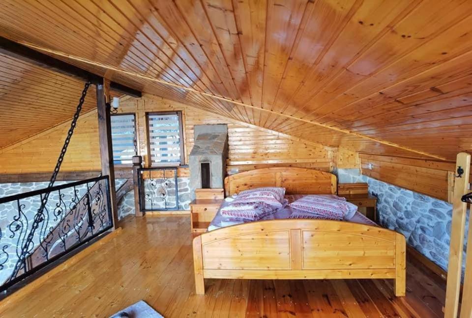 ein Schlafzimmer in einem Blockhaus mit einem Bett in der Unterkunft Chalet A-frame in Lupeni