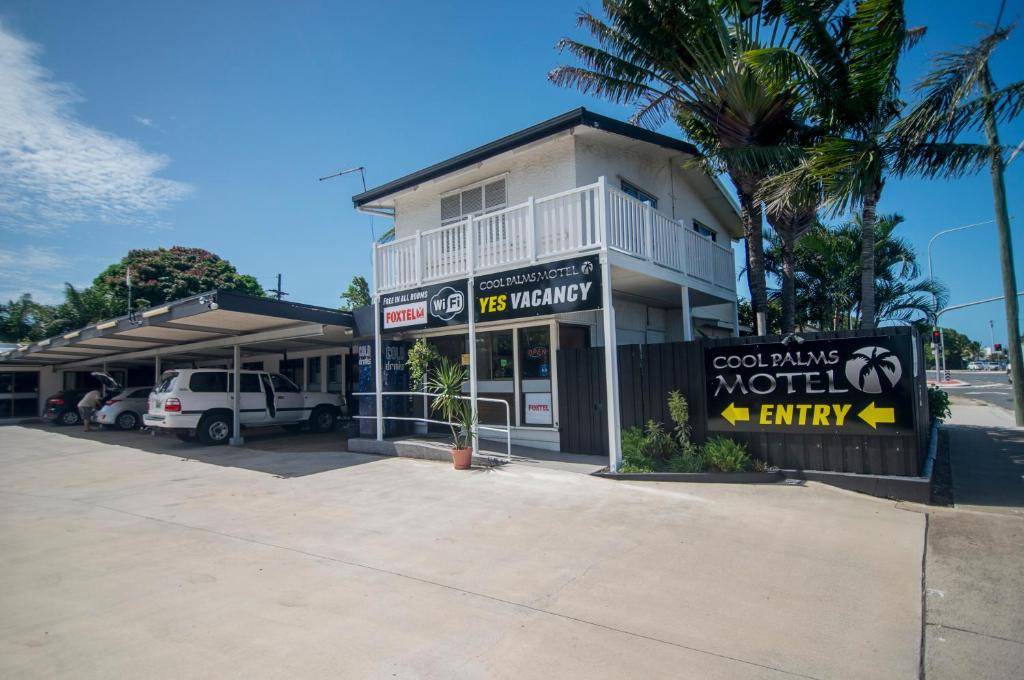 a motel entry sign in front of a building at Cool Palms Motel in Mackay