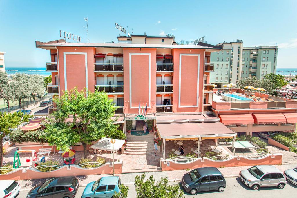 hotel z samochodami zaparkowanymi na parkingu w obiekcie Hotel Joli w Cesenatico