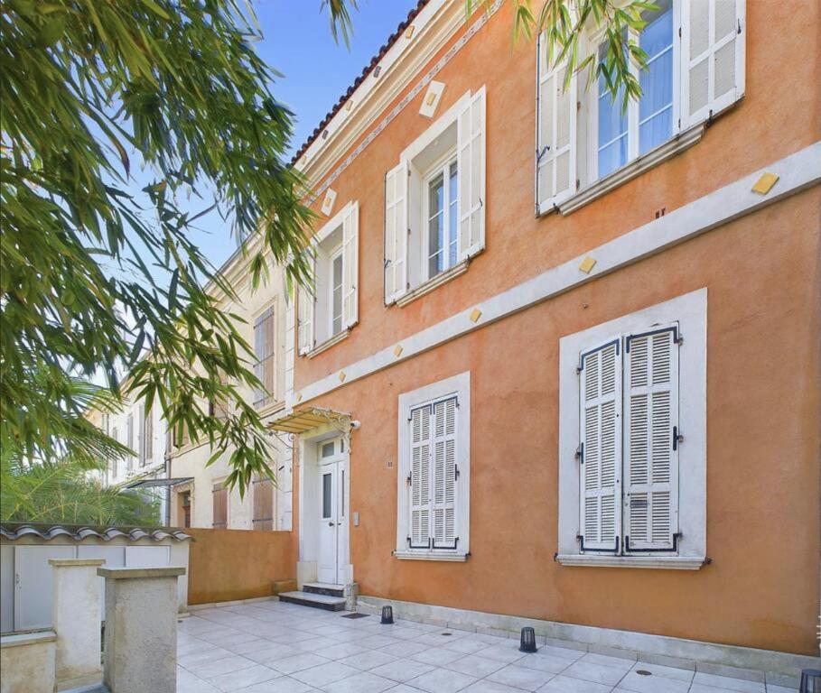 un bâtiment orange avec des fenêtres et des portes blanches dans l'établissement Residence Villa Ange, à La Seyne-sur-Mer
