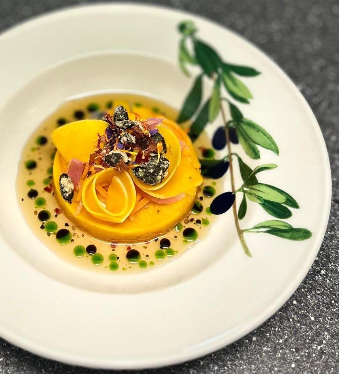 ein weißer Teller mit einer Schüssel Essen auf einem Tisch in der Unterkunft Boutique Hotel Dorer in Schönwald