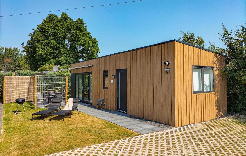 ein kleines Holzhaus mit einer Bank im Hof in der Unterkunft Nice Home In Heinkenszand With Wifi in Heinkensand
