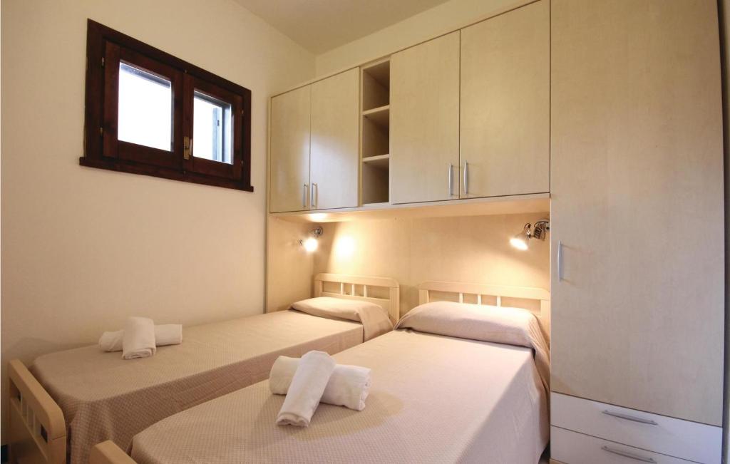 2 łóżka w pokoju z białymi ścianami i oknem w obiekcie Stunning Apartment In Costa Rei -Ca- w mieście Monte Nai