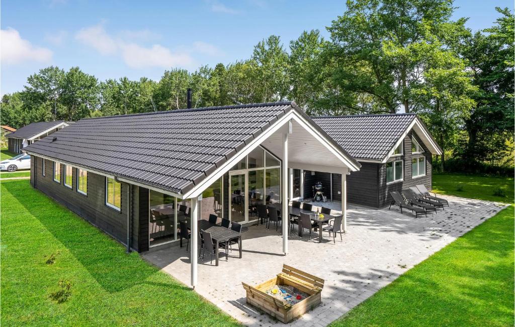 a log cabin with a pitched roof and a patio at Beautiful Home In Væggerløse With Sauna in Marielyst