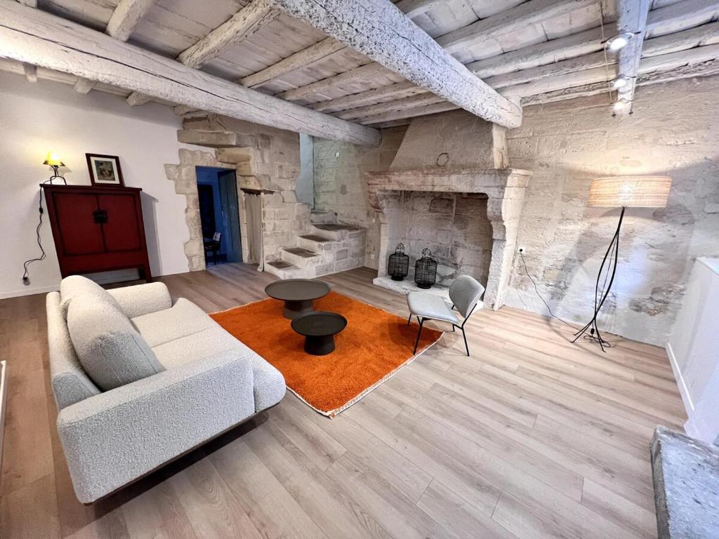 un salon avec un canapé blanc et une cheminée dans l'établissement Maison authentique centre historique, à Villeneuve-lès-Avignon