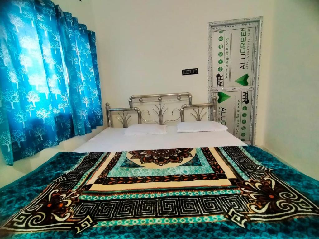 a bedroom with a bed with a bedspread on it at Shivay Guest house in Jasidih