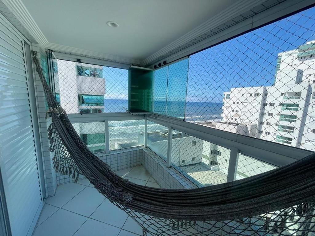 a balcony with a hammock on top of a building at Apartamento completo no Centro- Mongaguá Pé na areia in Mongaguá