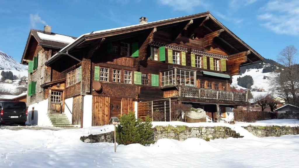 a large wooden house with snow on the ground at 300 years old Chalet close to Center ski-lift in Chateau-d'Oex