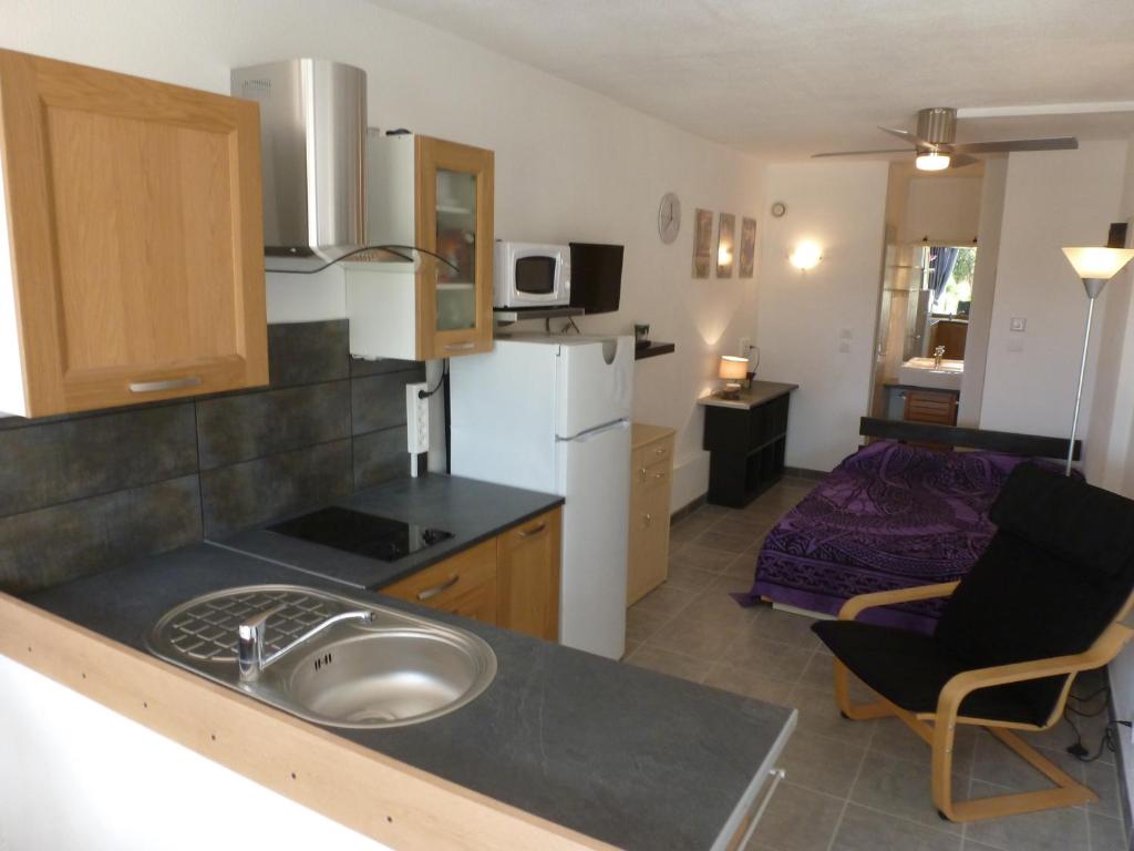 une cuisine avec un évier et une chambre avec un lit dans l'établissement Studio Village Naturiste Purple, au Cap d'Agde